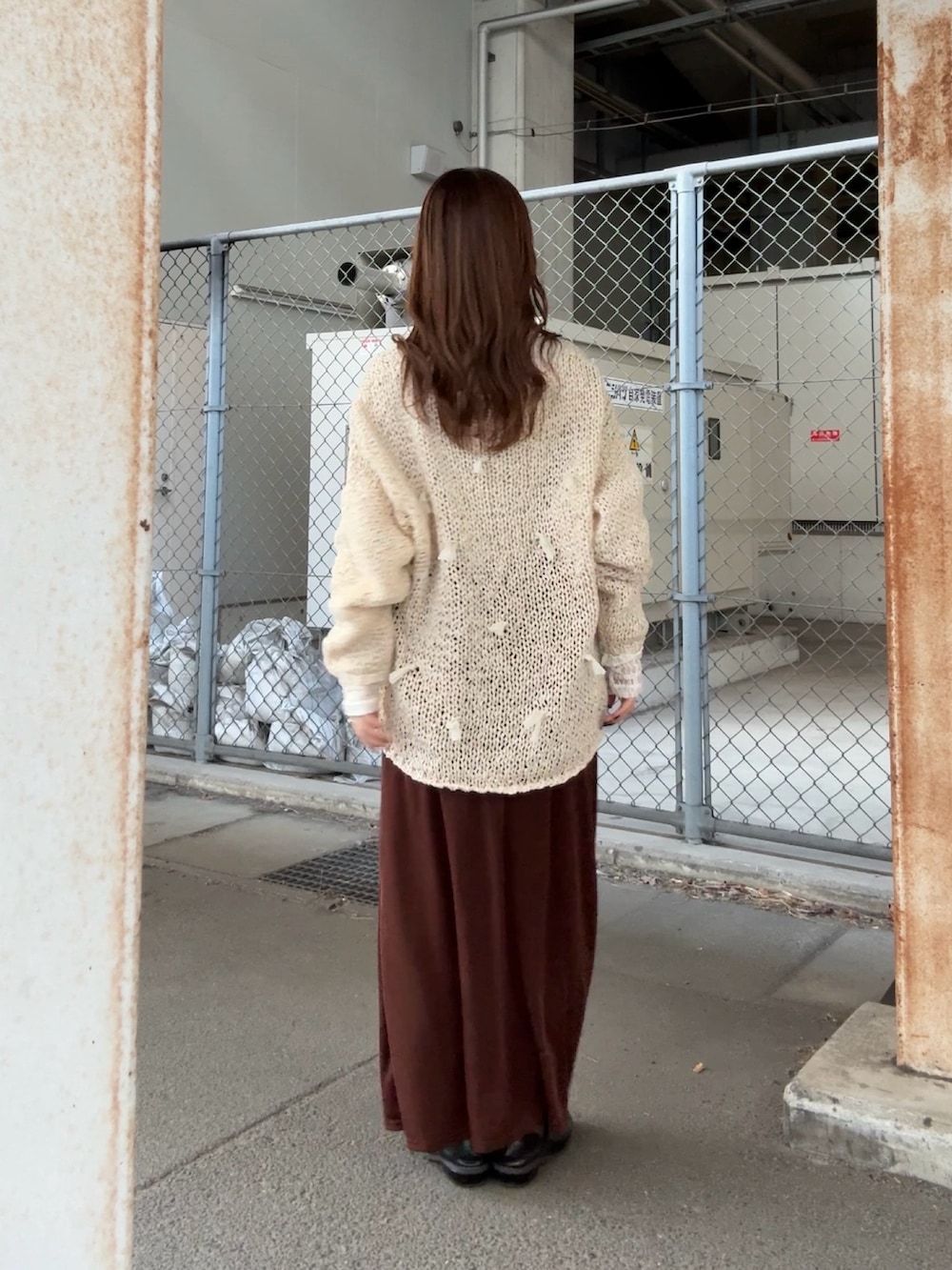 ホワイト系のニット/セーター、ホワイト系のTシャツ/カットソー、ブラウン系のスカートを着用したレディースの冬コーディネートの3枚目の写真