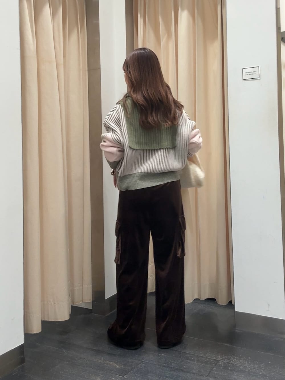 グリーン系のニット/セーター、ブラウン系のその他パンツ、ホワイト系のマフラーを着用したレディースの冬コーディネートの3枚目の写真