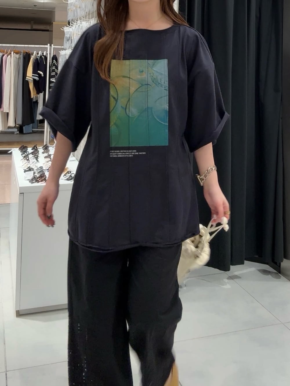 ブルー系のTシャツ/カットソー、ブラック系のその他パンツ、イエロー系のパンプスを着用したレディースの春コーディネートの4枚目の写真