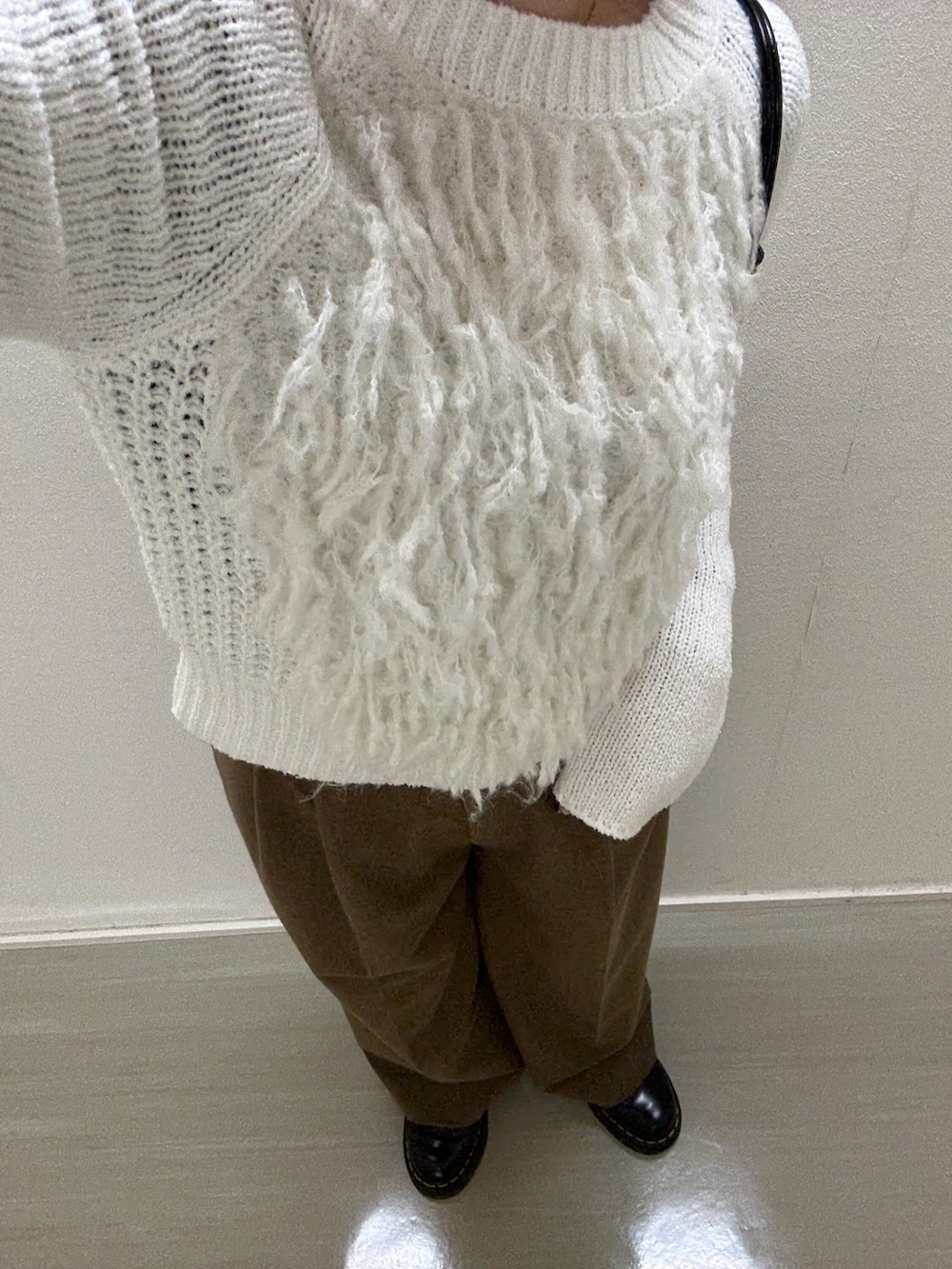 ホワイト系のニット/セーター、ブラウン系のその他パンツ、ブラック系の財布を着用したレディースの冬コーディネートの4枚目の写真