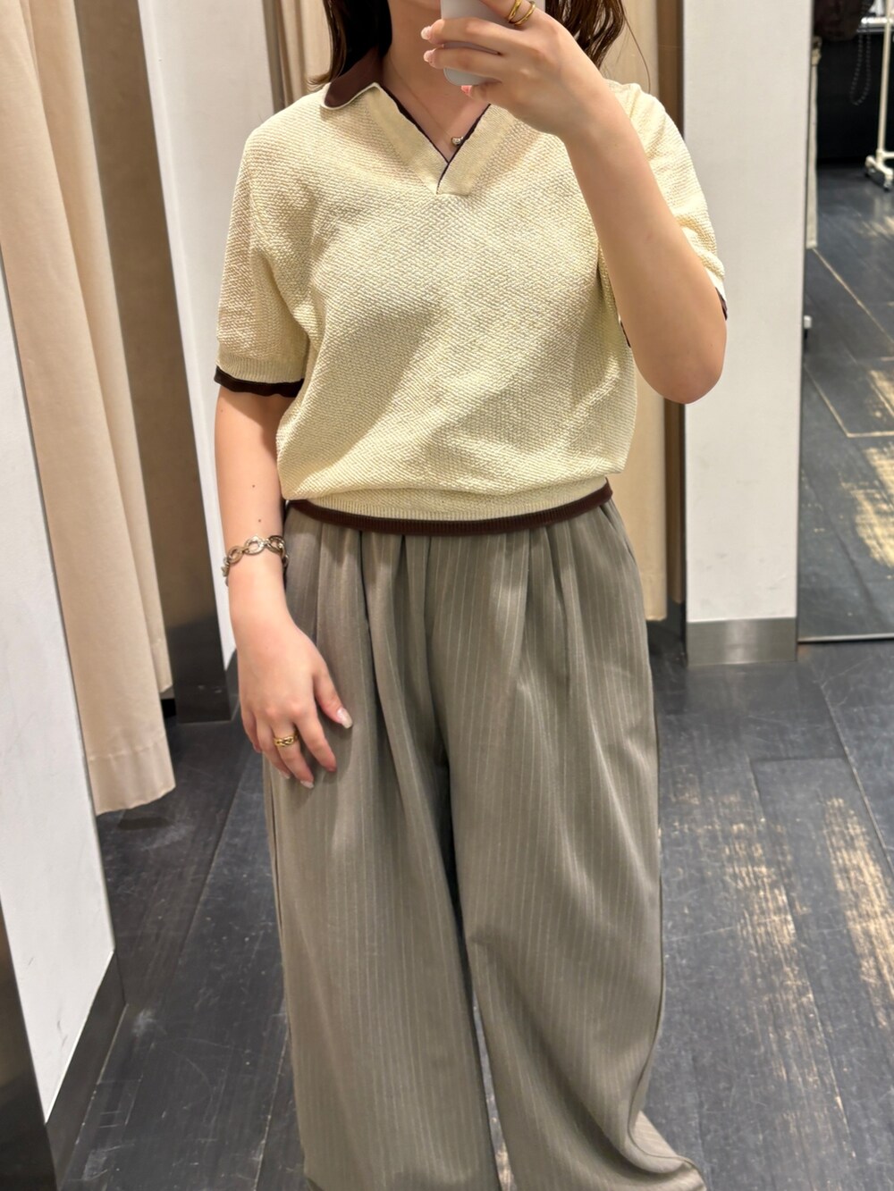イエロー系のニット/セーター、ブラウン系のその他パンツ、ホワイト系のサンダルを着用したレディースの春コーディネートの4枚目の写真