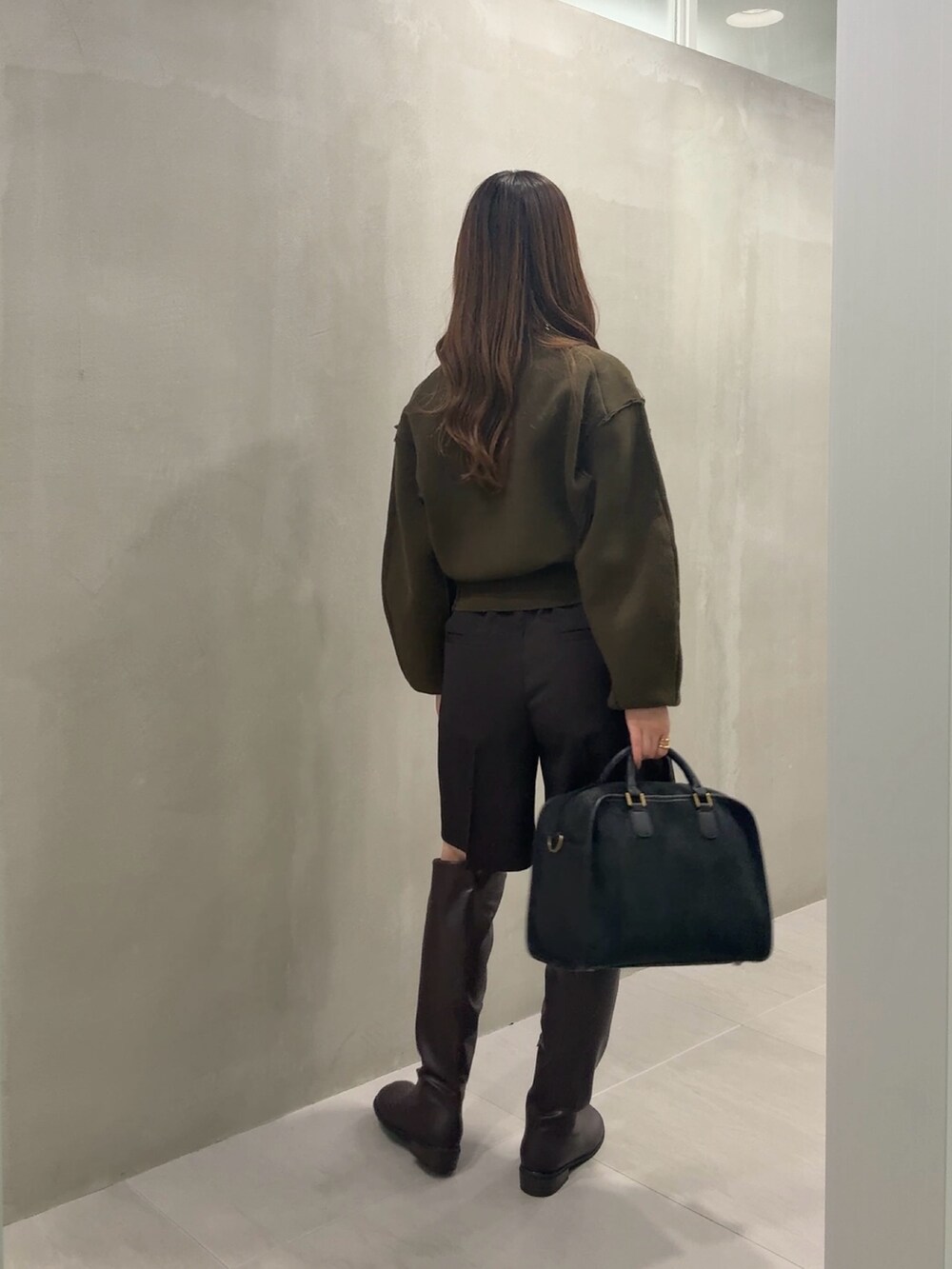 グリーン系のニット/セーター、ブラウン系のその他パンツ、ブラウン系のブーツを着用したレディースの冬コーディネートの3枚目の写真