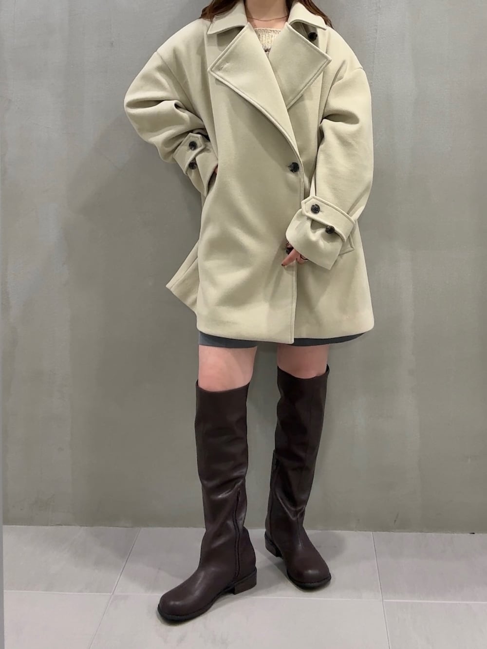 ベージュ系のその他アウター、グレー系のその他パンツ、ブラウン系のブーツを着用したレディースの秋コーディネートの2枚目の写真