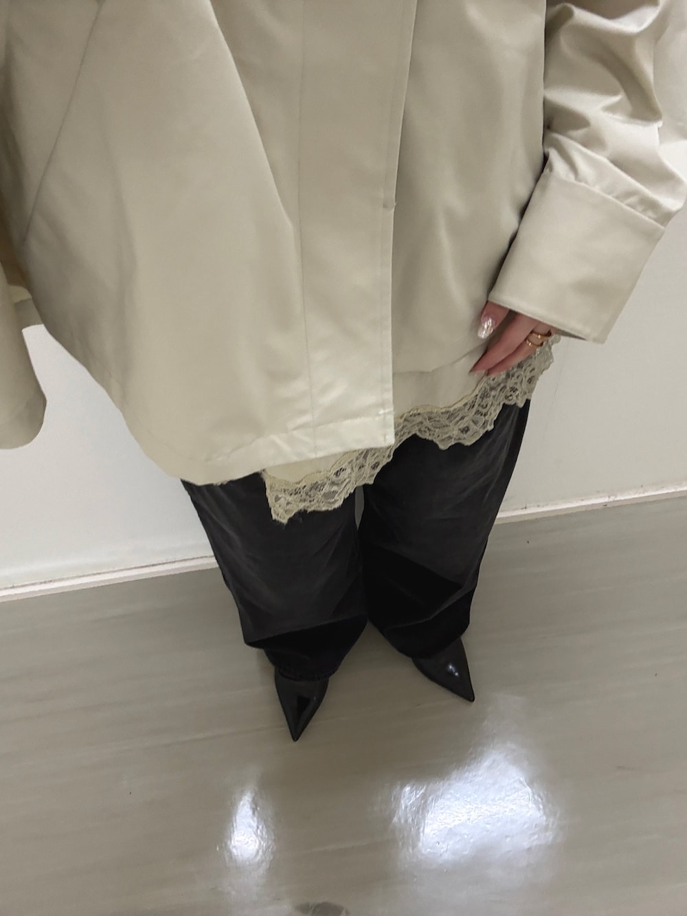 グレー系のステンカラーコート、ベージュ系のキャミソール、ブラック系のデニムパンツを着用したレディースの冬コーディネートの4枚目の写真