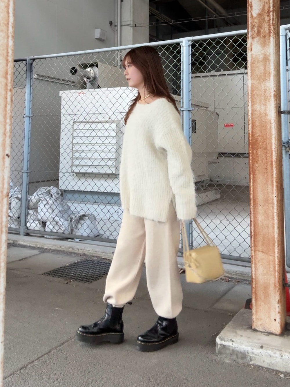 ホワイト系のニット/セーター、ベージュ系のその他パンツ、ベージュ系のショルダーバッグを着用したレディースの冬コーディネートの2枚目の写真