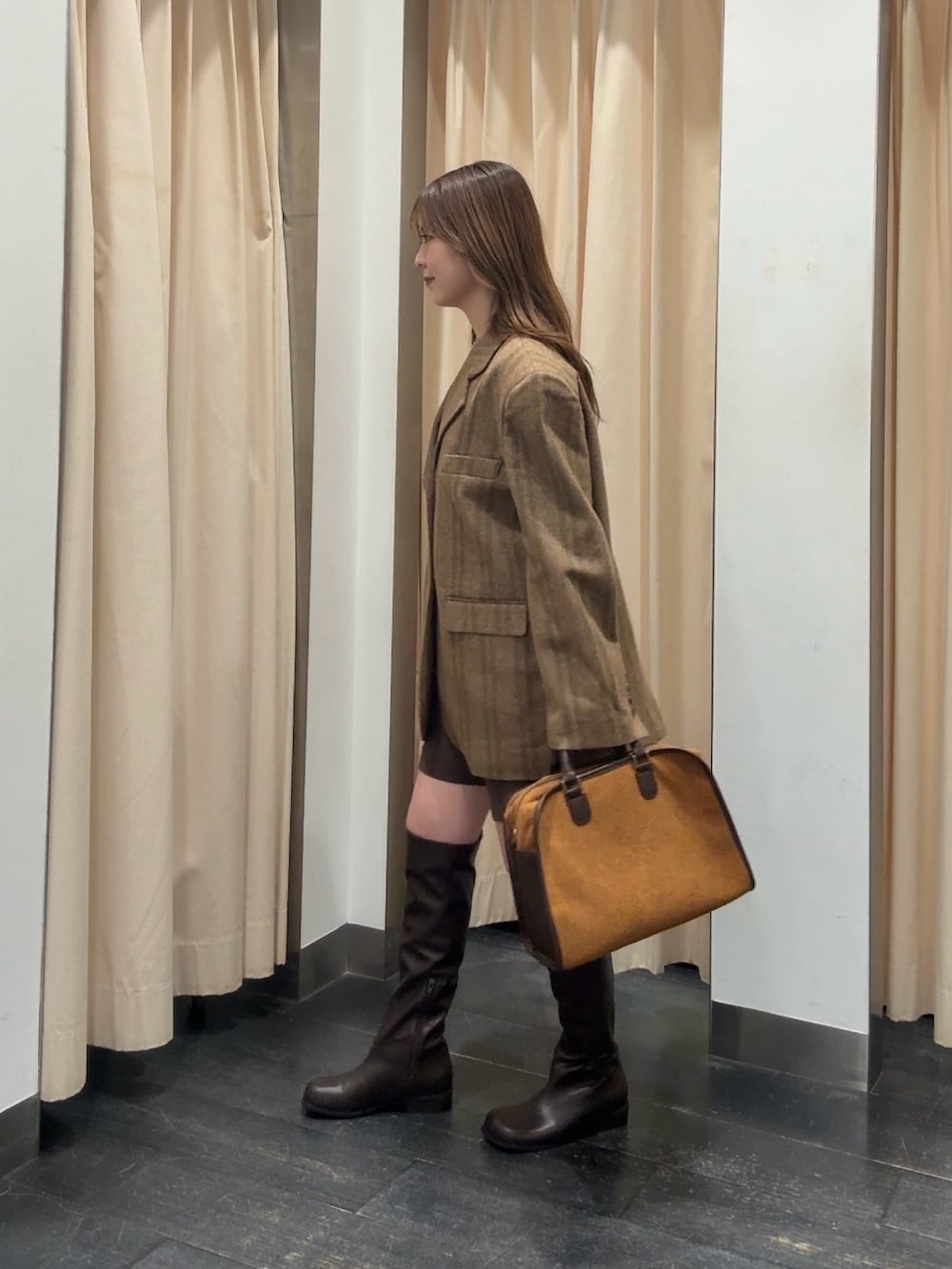 オレンジ系のその他アウター、ブラウン系のその他パンツ、イエロー系のボストンバッグを着用したレディースの秋コーディネートの2枚目の写真