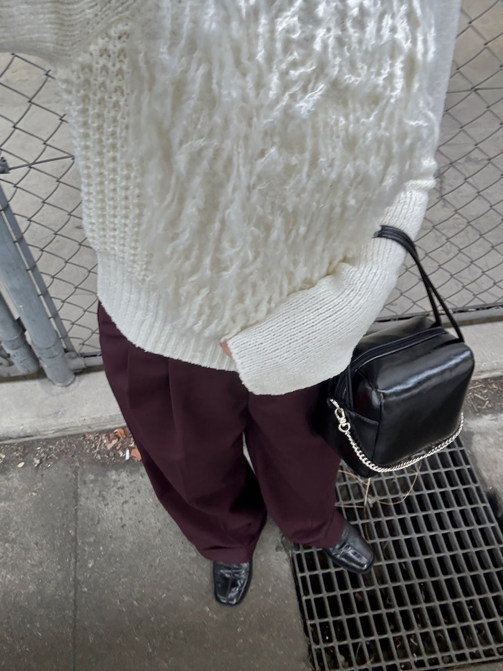 ホワイト系のニット/セーター、ブラック系のショルダーバッグ、レッド系のその他パンツを着用したレディースの冬コーディネートの4枚目の写真