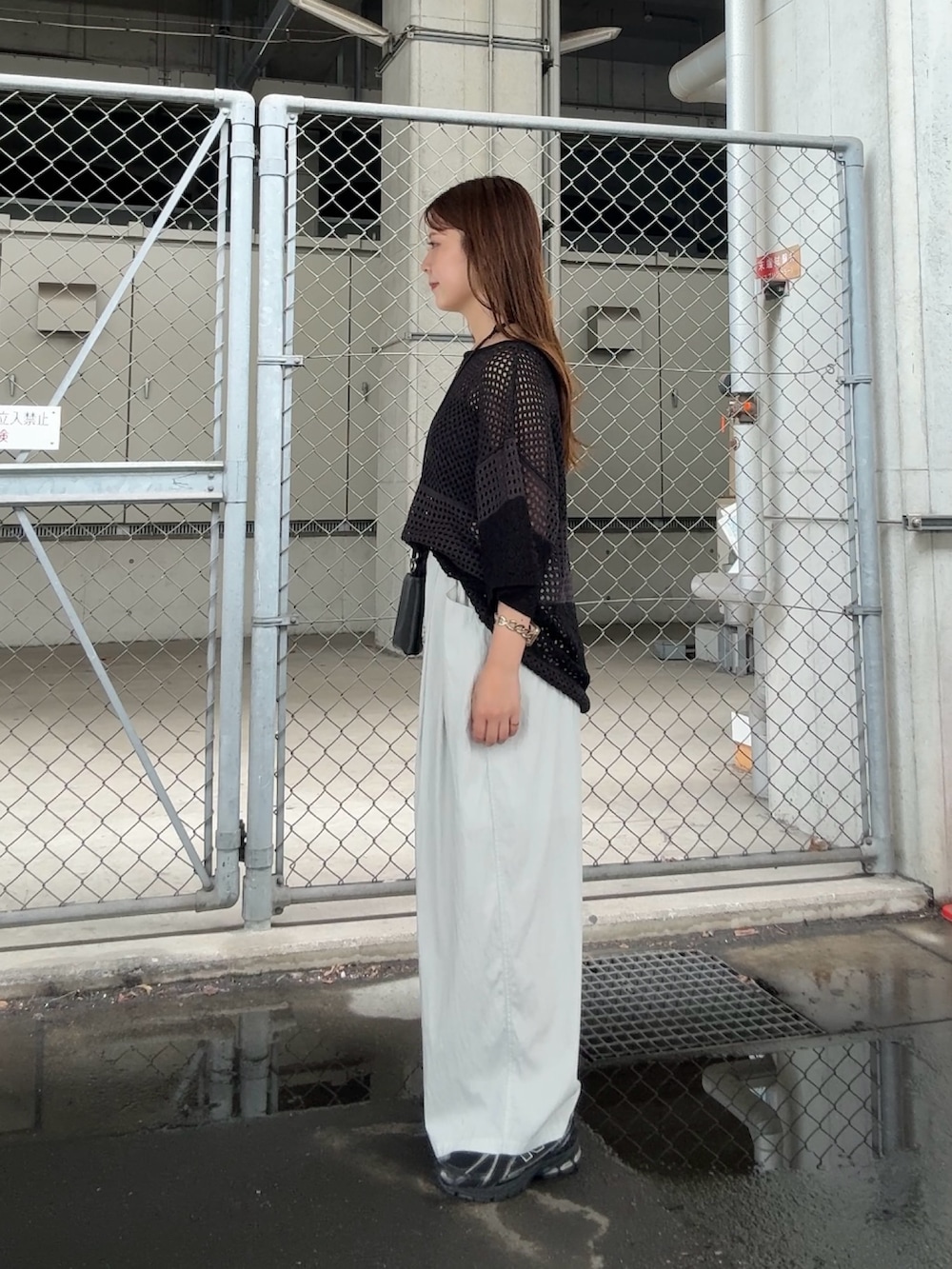 グレー系のニット/セーター、ブルー系のその他パンツ、ブラック系のポーチを着用したレディースの夏コーディネートの2枚目の写真