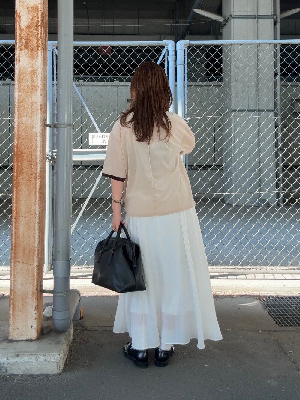 ホワイト系のスカート、ベージュ系のTシャツ/カットソー、ブラック系のボストンバッグを着用したレディースの夏コーディネートの4枚目の写真