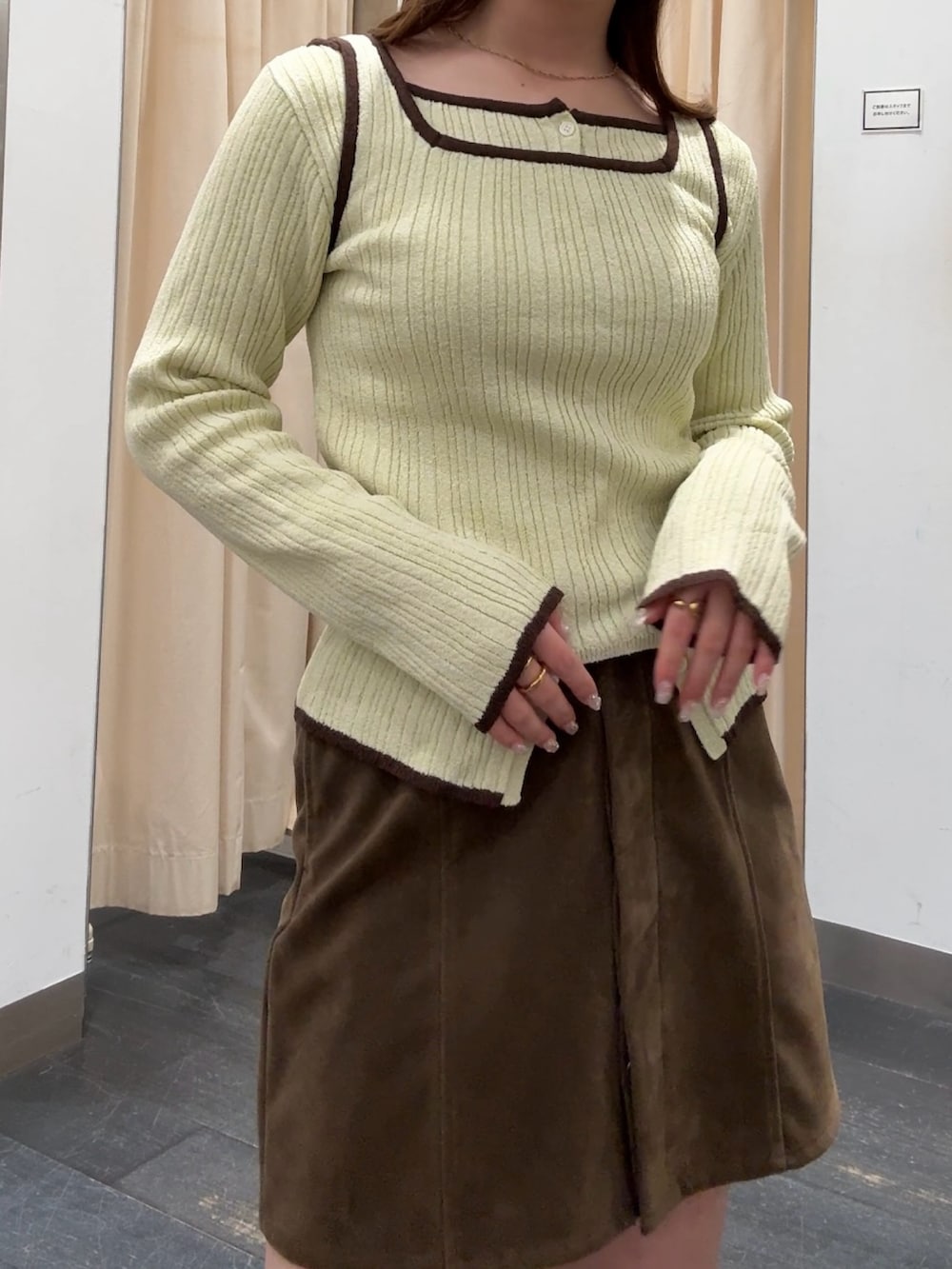 グリーン系のニット/セーター、ブラック系のブーツ、ブラウン系のニットキャップ/ビーニーを着用したレディースの冬コーディネートの4枚目の写真