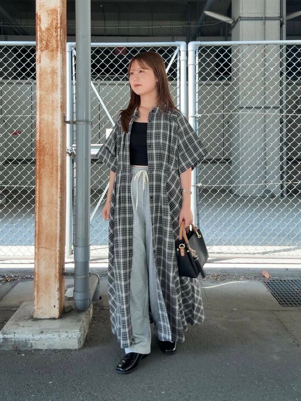 ブラック系のトートバッグ、グレー系のその他パンツ、ブラック系のワンピースを着用したレディースの夏コーディネートの2枚目の写真