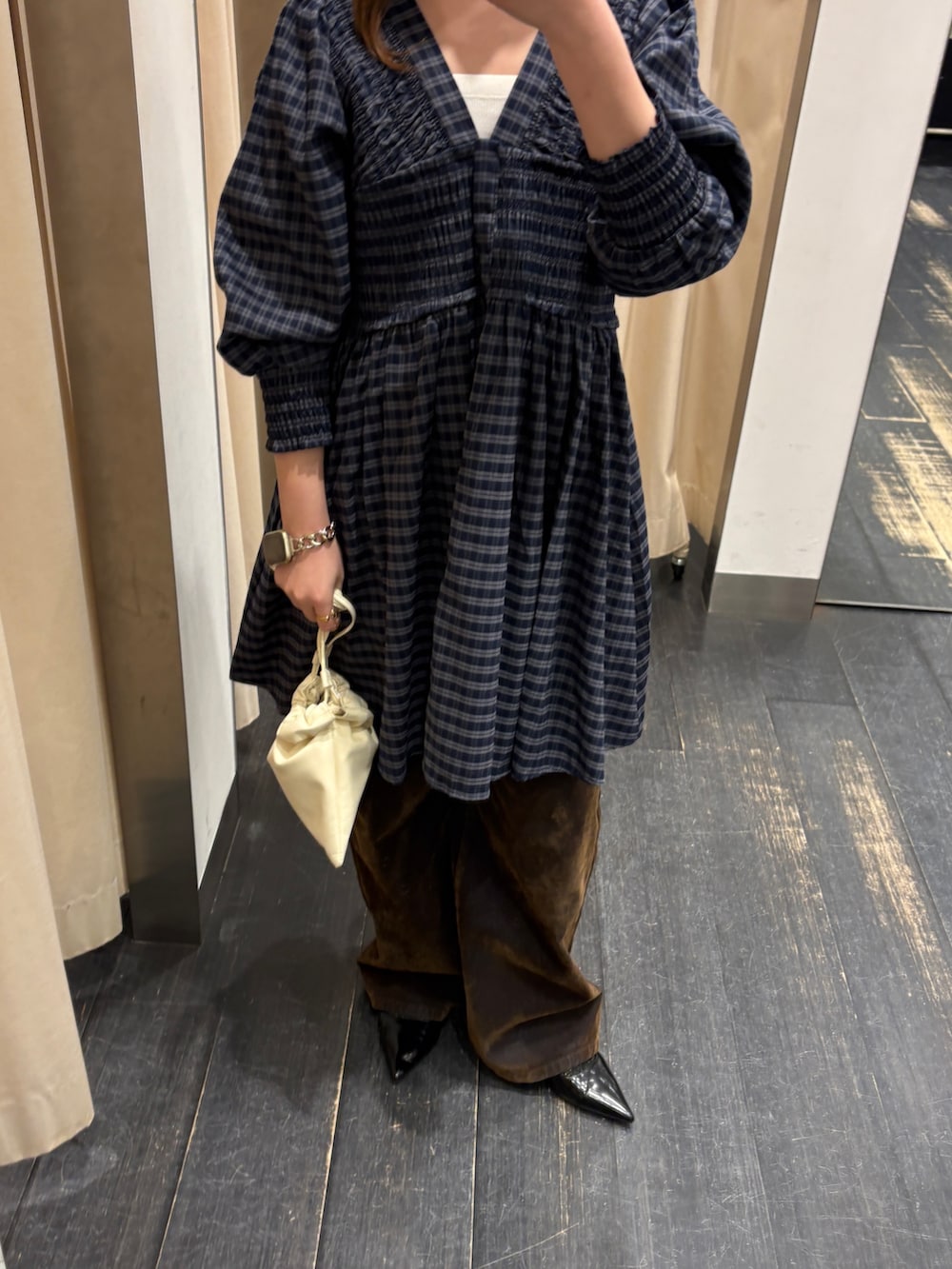 ブルー系のワンピース、ホワイト系のショルダーバッグ、ブラウン系のデニムパンツを着用したレディースの春コーディネートの4枚目の写真