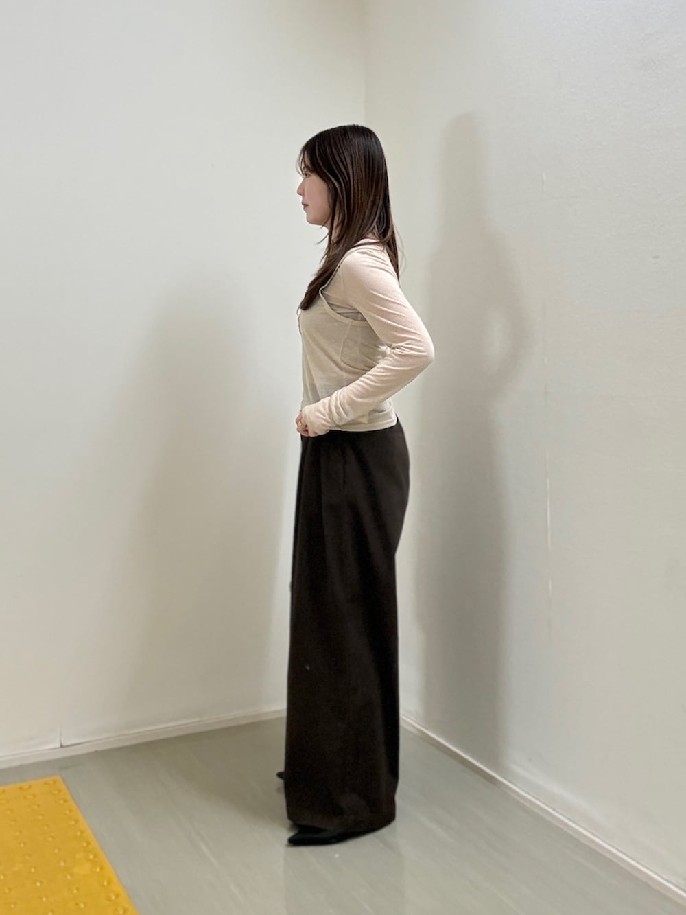 ピンク系のショルダーバッグ、ベージュ系のTシャツ/カットソー、ブラウン系のその他パンツを着用したレディースの春コーディネートの2枚目の写真