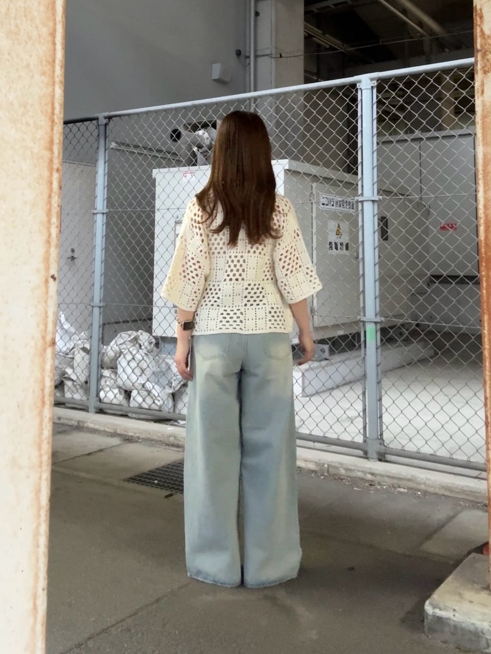 ホワイト系のニット/セーター、ブルー系のデニムパンツ、ホワイト系のポーチを着用したレディースの春コーディネートの3枚目の写真
