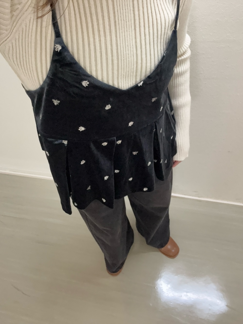 グレー系のキャミソール、ホワイト系のニット/セーター、ブラック系のデニムパンツを着用したレディースの秋コーディネートの4枚目の写真