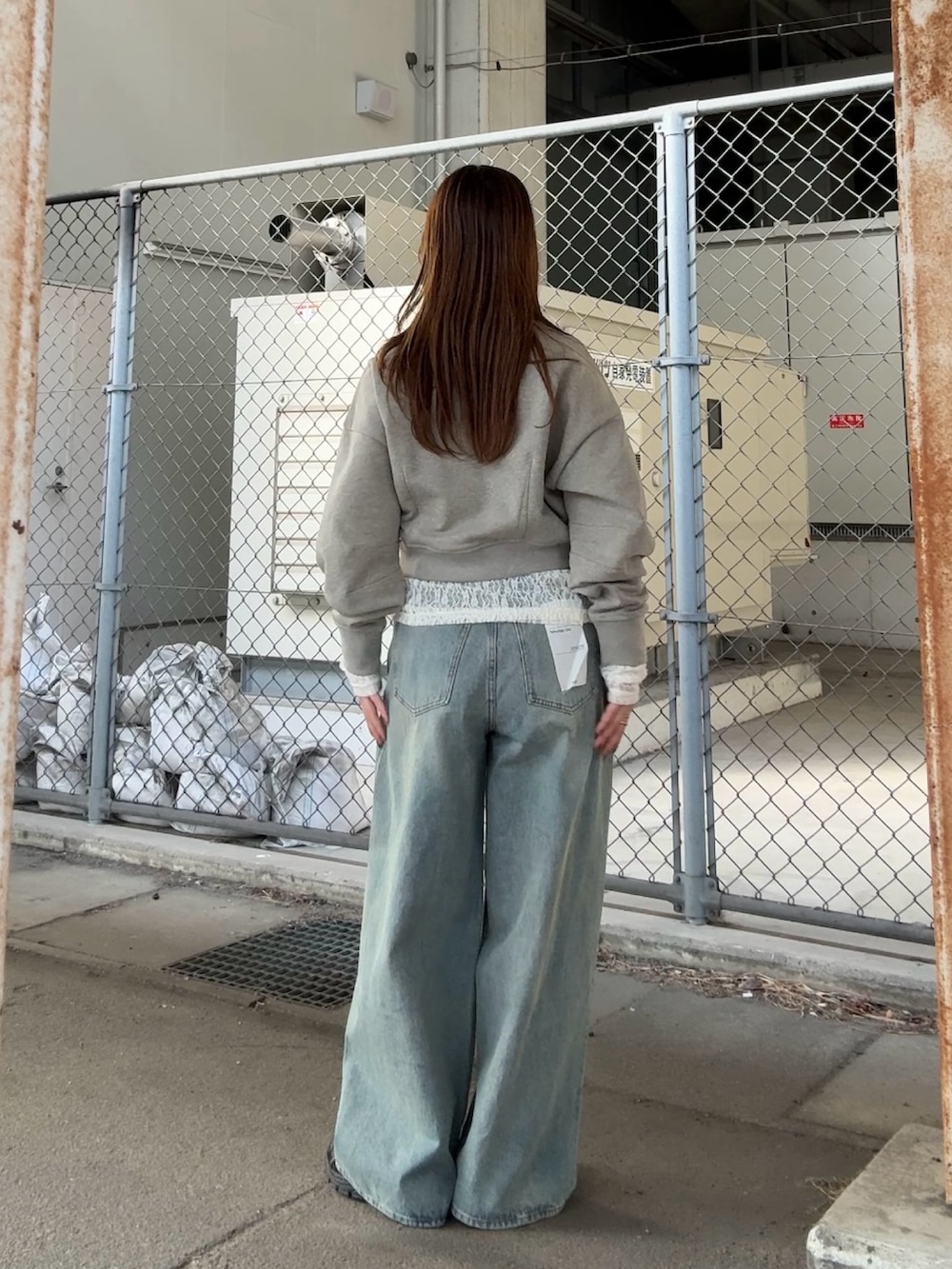 ベージュ系のスウェット、ホワイト系のTシャツ/カットソー、ブルー系のデニムパンツを着用したレディースの冬コーディネートの3枚目の写真