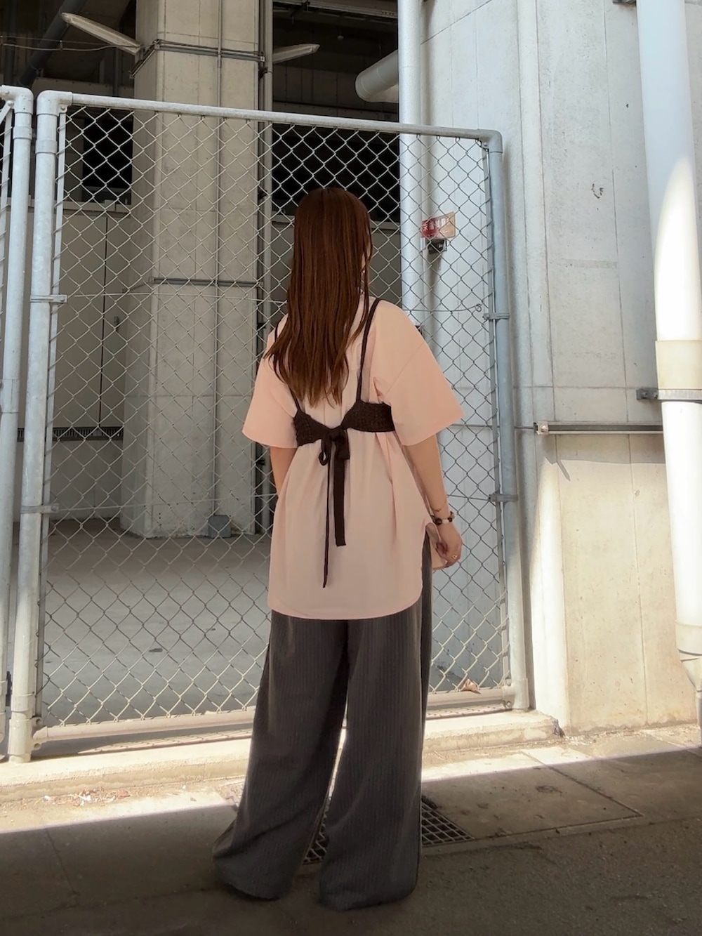 ピンク系のシャツ/ブラウス、グレー系のその他パンツ、ブラウン系のヘアゴムを着用したレディースの夏コーディネートの3枚目の写真