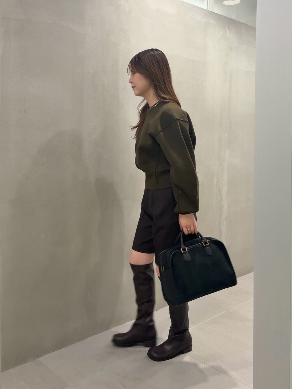 グリーン系のニット/セーター、ブラウン系のその他パンツ、ブラウン系のブーツを着用したレディースの冬コーディネートの2枚目の写真