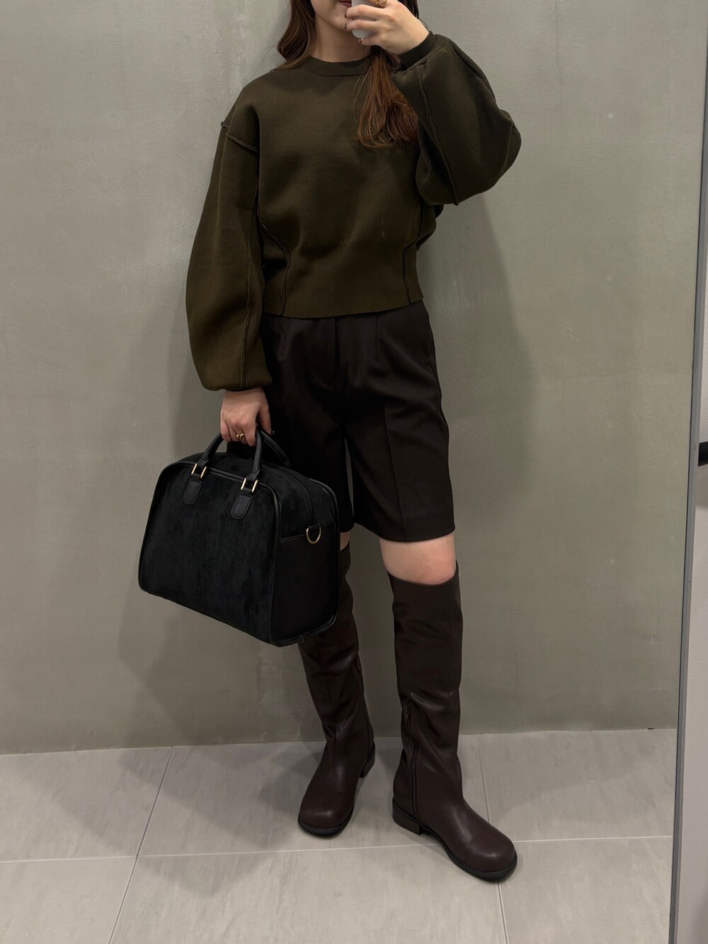 グリーン系のニット/セーター、ブラウン系のその他パンツ、ブラウン系のブーツを着用したレディースの冬コーディネートの4枚目の写真