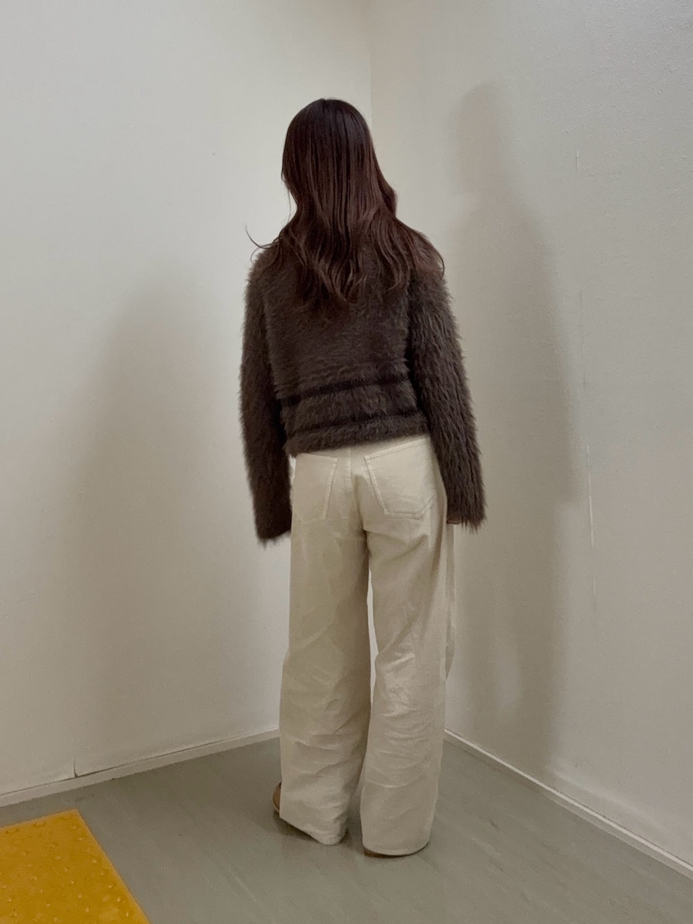 ブラウン系のニット/セーター、ホワイト系のその他パンツ、ベージュ系のその他シューズを着用したレディースの冬コーディネートの3枚目の写真