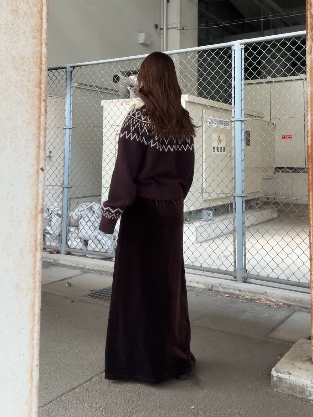 レッド系のニット/セーター、ブラウン系のスカート、ホワイト系のマフラーを着用したレディースの冬コーディネートの4枚目の写真