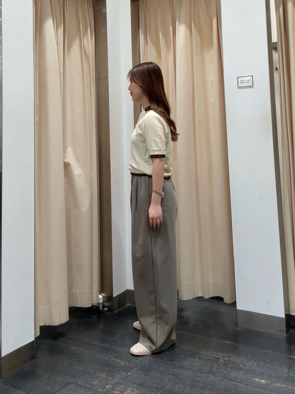 イエロー系のニット/セーター、ブラウン系のその他パンツ、ホワイト系のサンダルを着用したレディースの春コーディネートの2枚目の写真