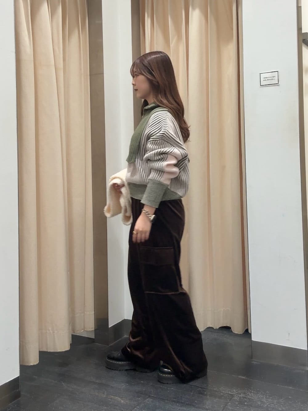 グリーン系のニット/セーター、ブラウン系のその他パンツ、ホワイト系のマフラーを着用したレディースの冬コーディネートの2枚目の写真