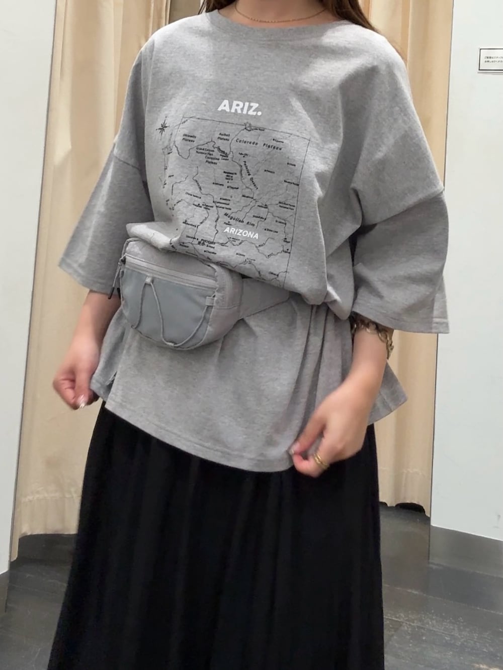 グレー系のTシャツ/カットソー、ブラック系のスカート、ベージュ系のスニーカーを着用したレディースの春コーディネートの4枚目の写真