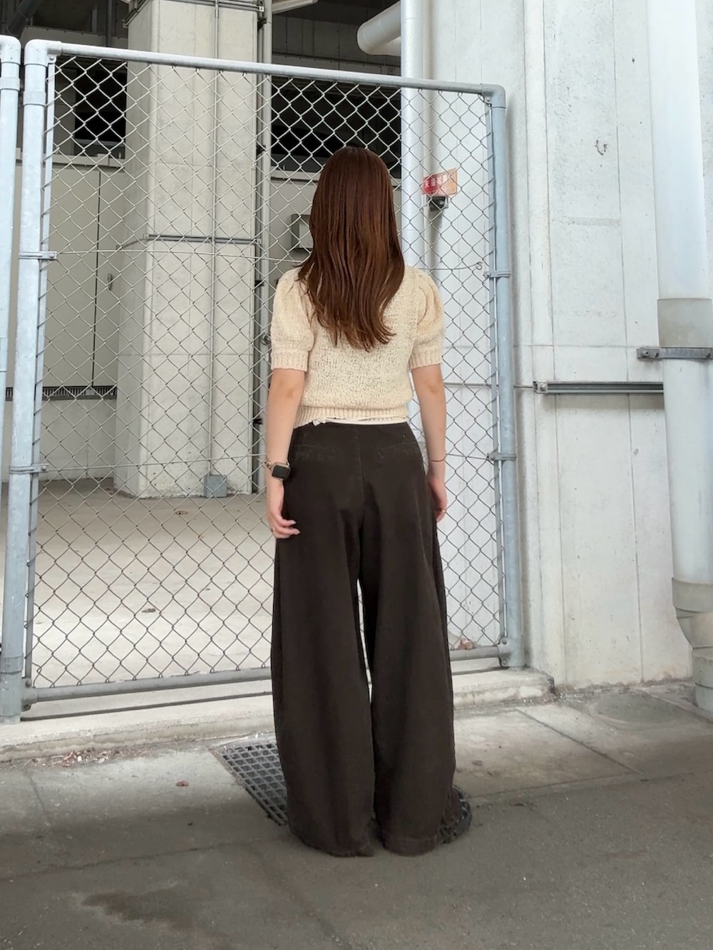 ホワイト系のニット/セーター、グレー系のその他パンツ、ホワイト系のポーチを着用したレディースの夏コーディネートの3枚目の写真