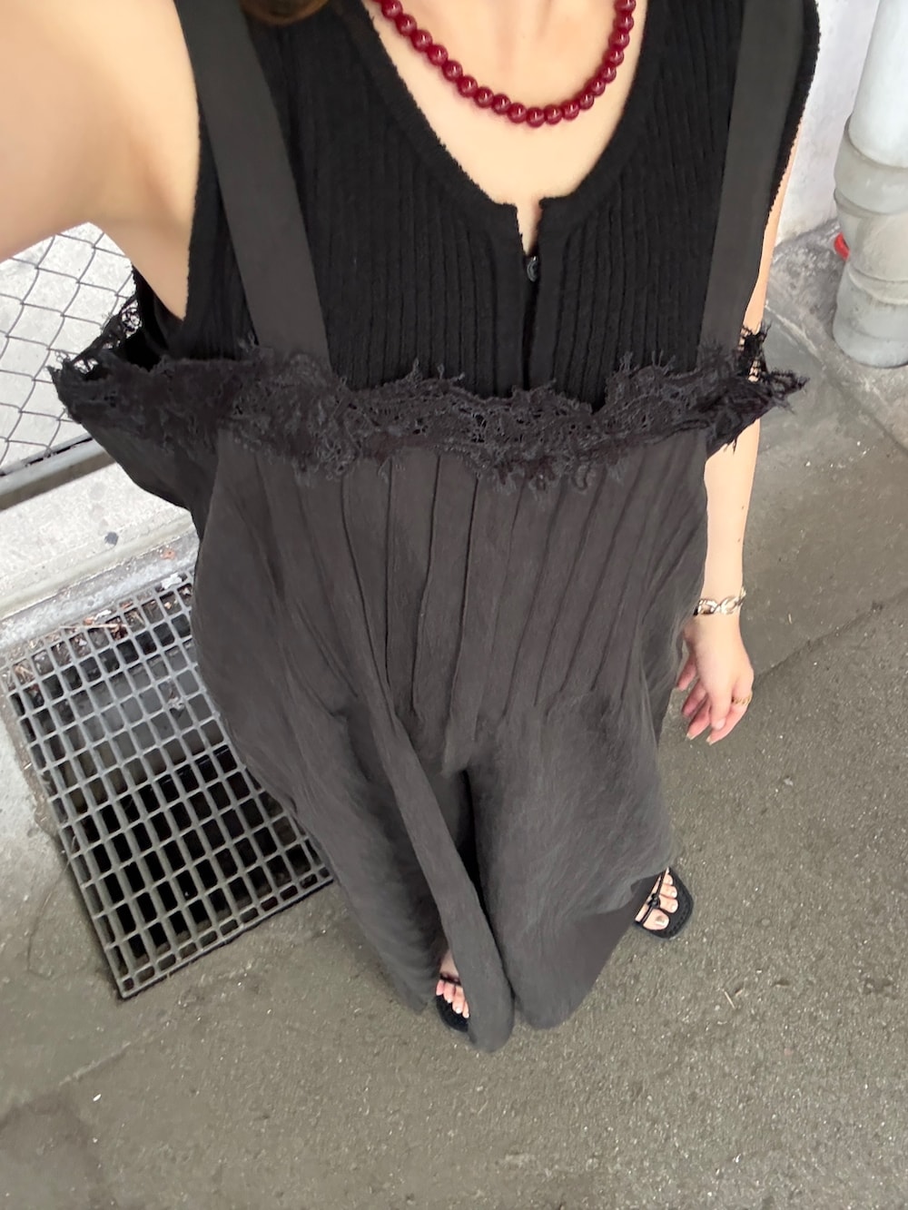 ブラック系のその他パンツ、ブラック系のベスト、レッド系のネックレスを着用したレディースの夏コーディネートの4枚目の写真