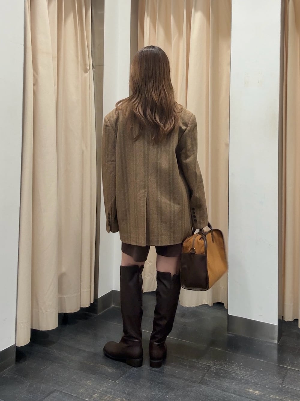 オレンジ系のその他アウター、ブラウン系のその他パンツ、イエロー系のボストンバッグを着用したレディースの秋コーディネートの3枚目の写真