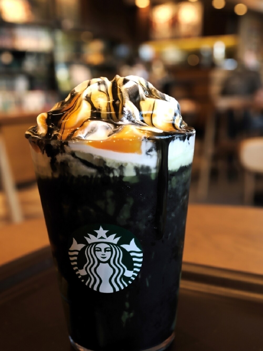 グリーン系のブルゾン、ブラウン系のニット/セーター、ブルー系のデニムパンツを着用したメンズの秋コーディネートの2枚目の写真