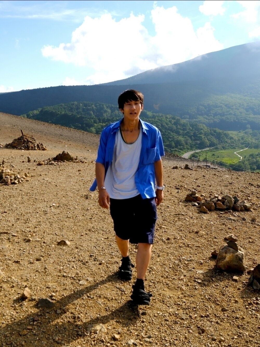 その他のタンクトップ、ブルー系のカーゴパンツ、ブラック系のサンダルを着用したメンズの夏コーディネートの4枚目の写真