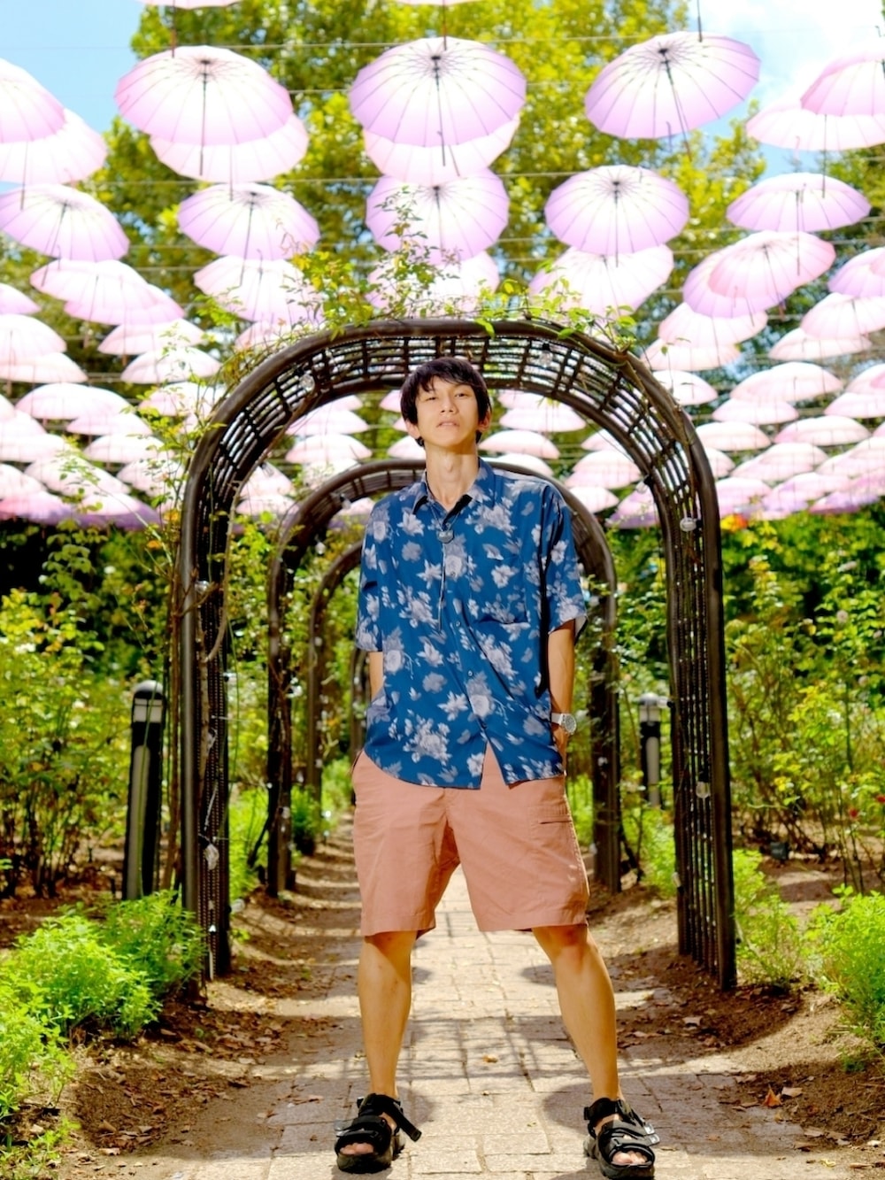 ブルー系のシャツ/ブラウス、ピンク系のその他パンツ、ブラック系のサンダルを着用したメンズの夏コーディネートの4枚目の写真