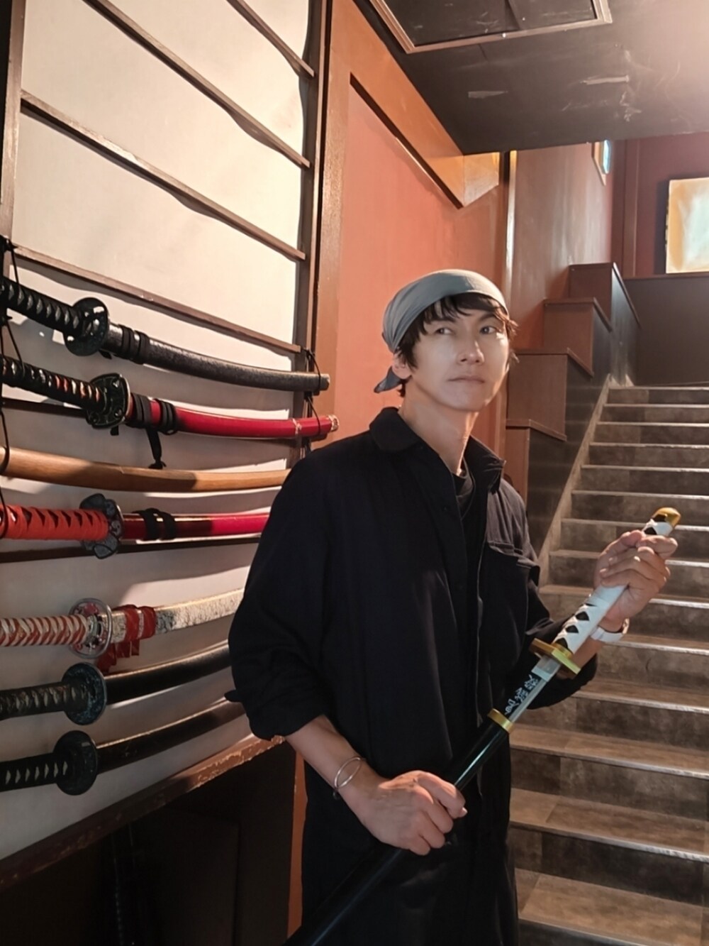 ブルー系のシャツ/ブラウス、レッド系のタンクトップ、グリーン系のショルダーバッグを着用したメンズの秋コーディネートの3枚目の写真