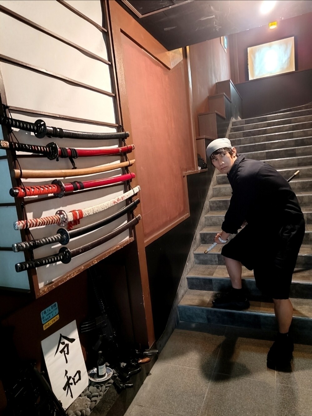 ブルー系のシャツ/ブラウス、レッド系のタンクトップ、グリーン系のショルダーバッグを着用したメンズの秋コーディネートの4枚目の写真