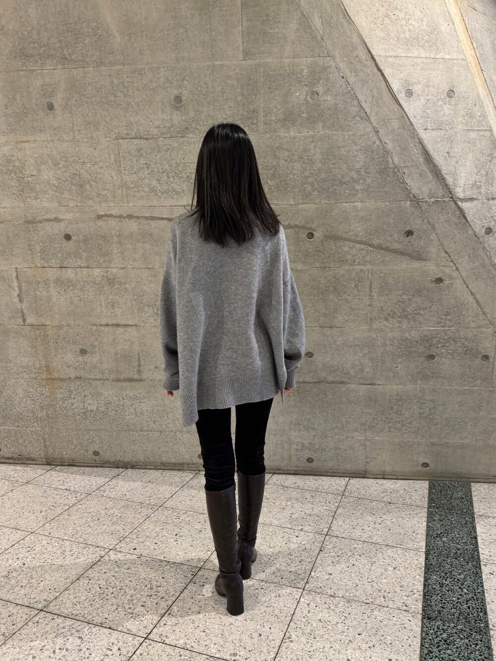 グレー系のニット/セーター、ブラック系のその他パンツ、ブラウン系のブーツを着用したレディースの冬コーディネートの2枚目の写真