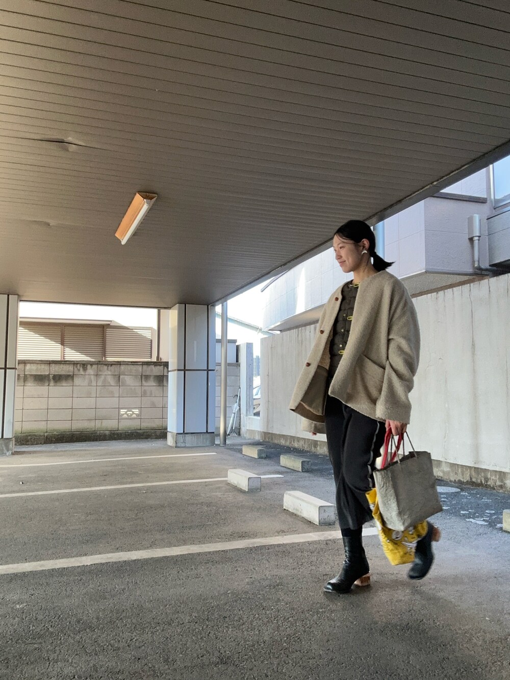 ベージュ系のジャケット/アウター、ブラック系のワンピース、その他のブーツを着用したレディースの春コーディネートの2枚目の写真