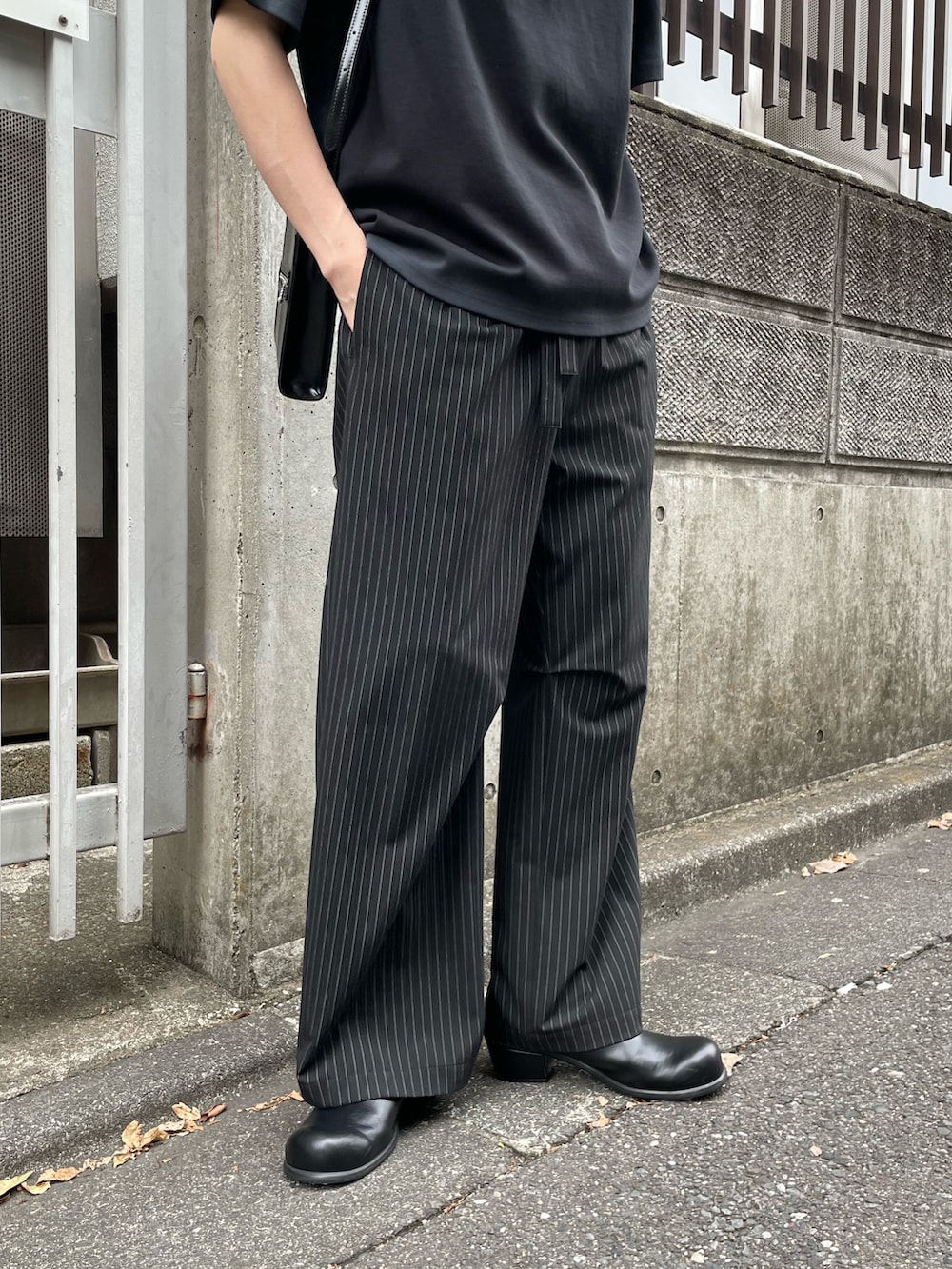 「ショルダーバッグ、モノトーン、サンダル、黒Tシャツ、ワイドパンツ、きれいめカジュアル、ストライプ、ストライプパンツ、プリントT、Tシャツ、革靴、夏、夏コーデ、キレイめ、オールブラック」｜「Lui'sのポンチスプレーTシャツ（Tシャツ/カットソー、ブラック系）」を使った、ますだ　みつきさん（骨格ナチュラル・メンズ・181cm）の春コーディネートの5枚目の写真