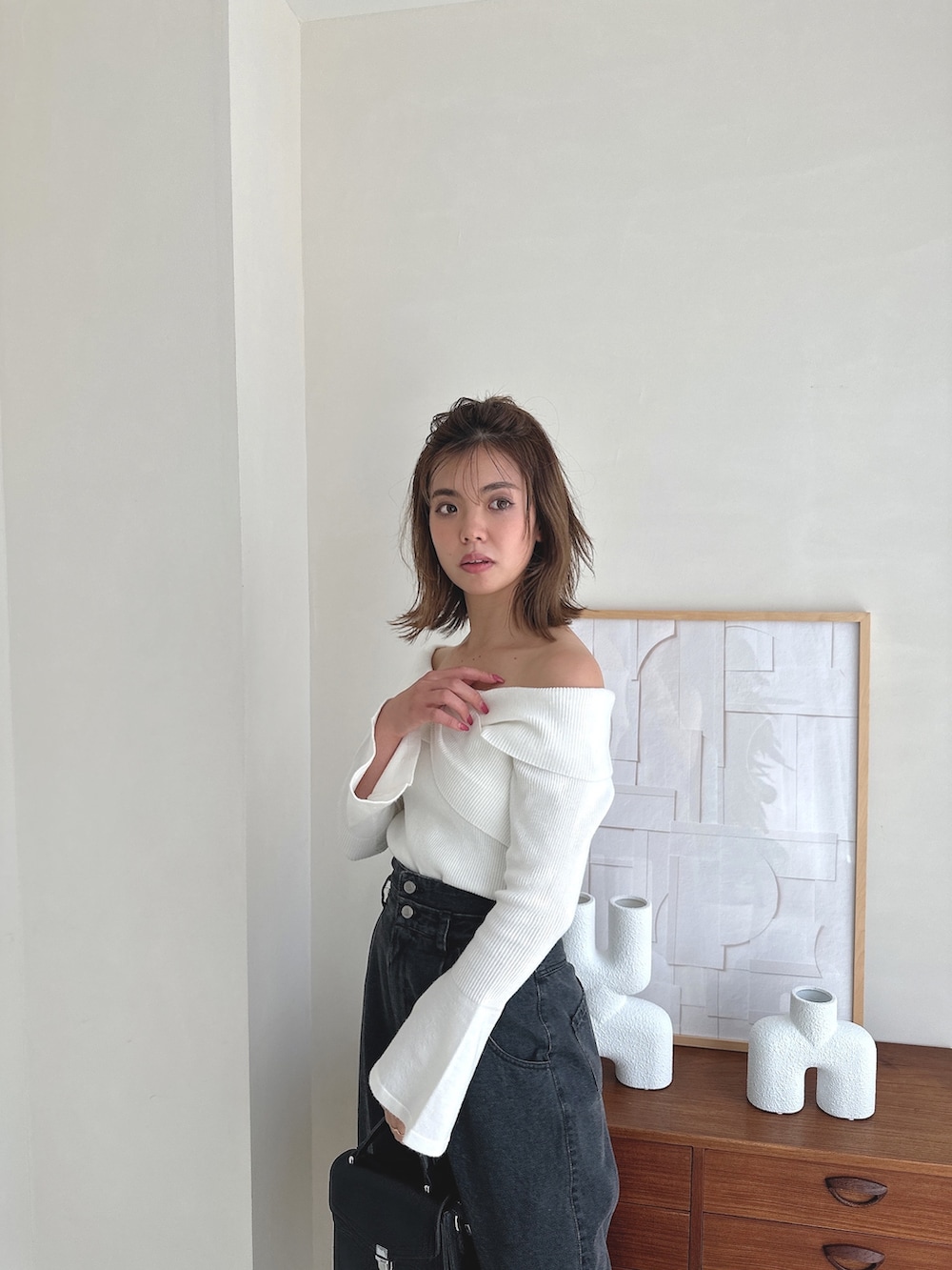 ホワイト系のニット/セーター、ブラック系のデニムパンツ、ブラック系のローファーを着用したレディースの夏コーディネートの4枚目の写真