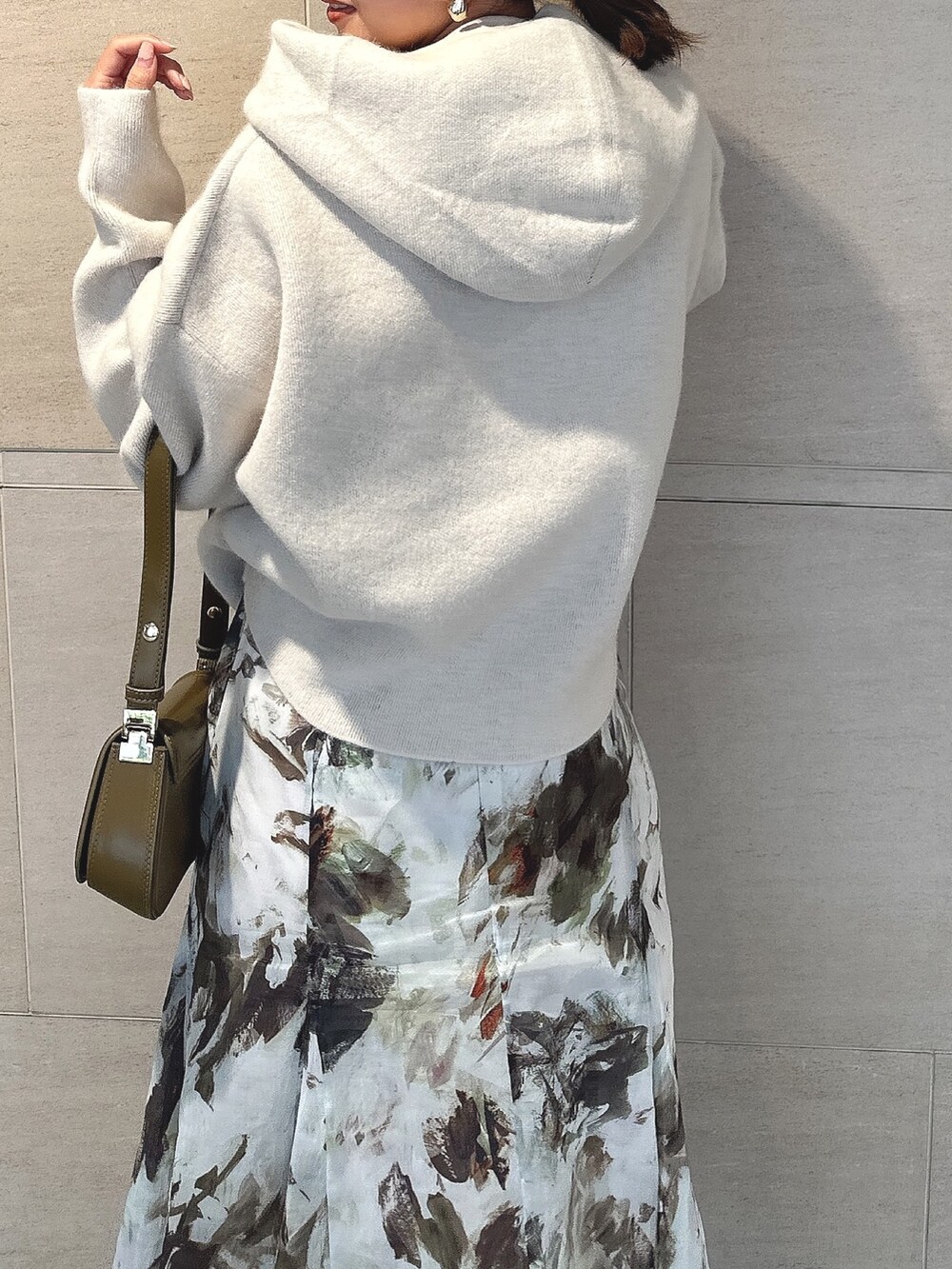 ホワイト系のパーカー、グリーン系のスカート、ブラック系のブーツを着用したレディースの秋コーディネートの8枚目の写真