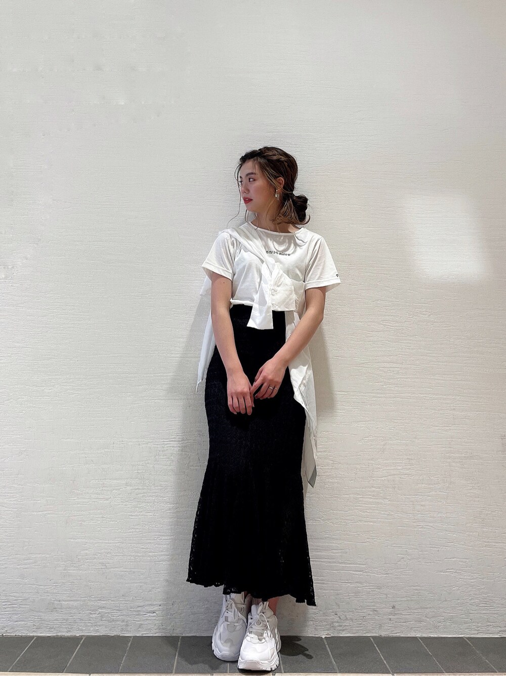ブラック系のスカート、ホワイト系のスニーカー、ホワイト系のシャツ/ブラウスを着用したレディースの春コーディネートの7枚目の写真