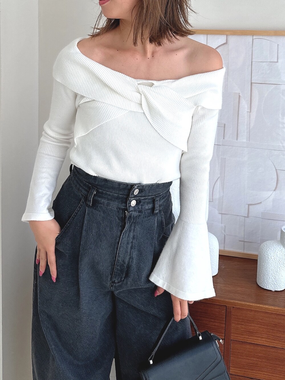 ホワイト系のニット/セーター、ブラック系のデニムパンツ、ブラック系のローファーを着用したレディースの夏コーディネートの5枚目の写真