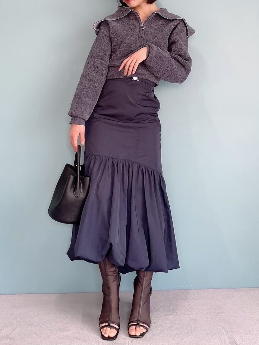 グレー系のニット/セーター、ブルー系のスカートを着用したレディースの夏コーディネートの3枚目の写真