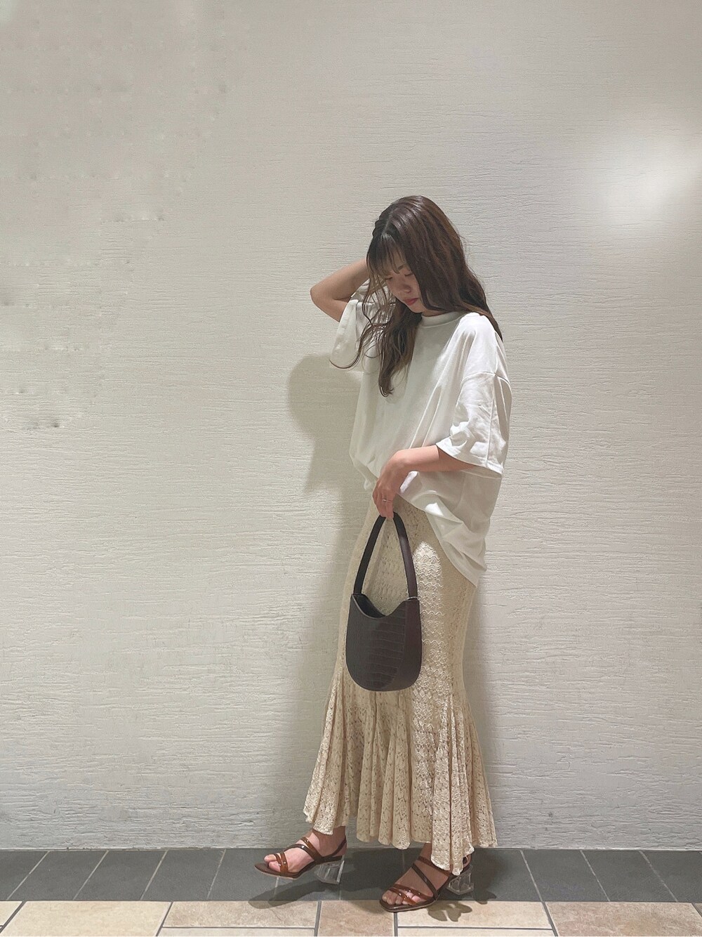 ブラウン系のサンダル、ホワイト系のTシャツ/カットソー、ホワイト系のスカートを着用したレディースの春コーディネートの3枚目の写真