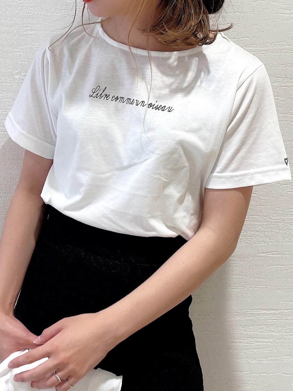 ブラック系のスカート、ホワイト系のスニーカー、ホワイト系のシャツ/ブラウスを着用したレディースの春コーディネートの3枚目の写真