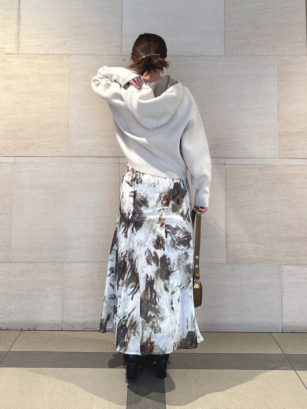 ホワイト系のパーカー、グリーン系のスカート、ブラック系のブーツを着用したレディースの秋コーディネートの2枚目の写真