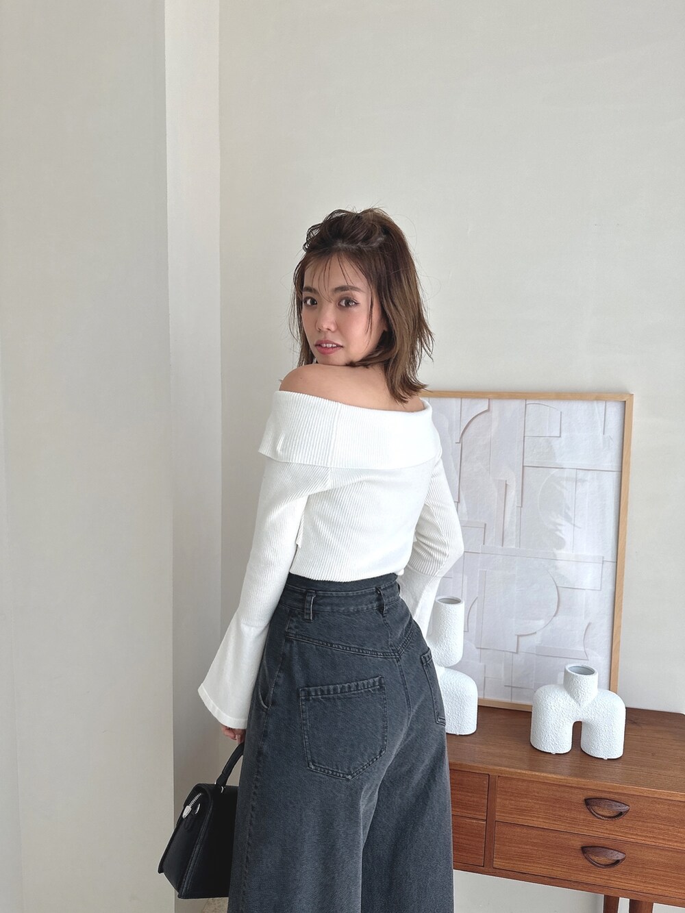 ホワイト系のニット/セーター、ブラック系のデニムパンツ、ブラック系のローファーを着用したレディースの夏コーディネートの6枚目の写真