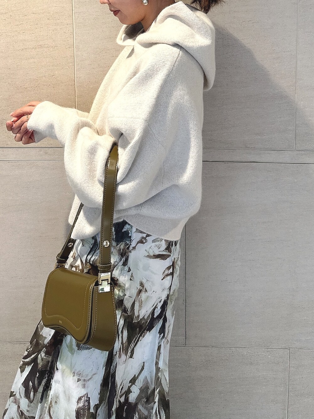 ホワイト系のパーカー、グリーン系のスカート、ブラック系のブーツを着用したレディースの秋コーディネートの7枚目の写真