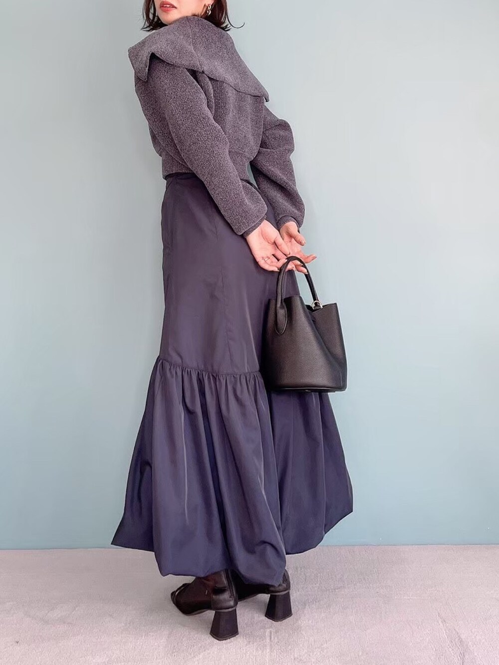 グレー系のニット/セーター、ブルー系のスカートを着用したレディースの夏コーディネートの2枚目の写真